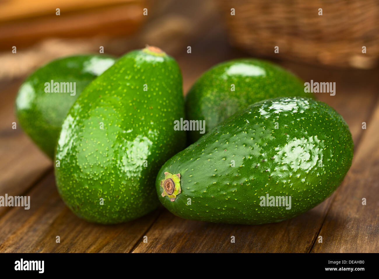 Four Avocados Fuerte on dark wood (Selective Focus, Focus on the front) Stock Photo