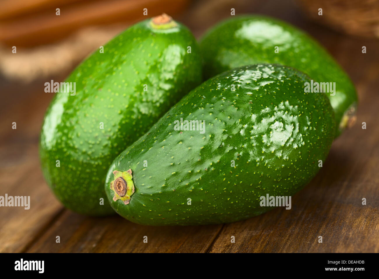 Three Avocados Fuerte on dark wood (Selective Focus, Focus on the front) Stock Photo