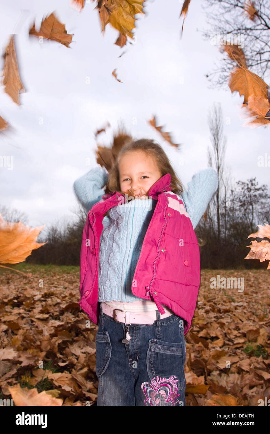 Playing girl, 4 years, outdoors in autumn Stock Photo