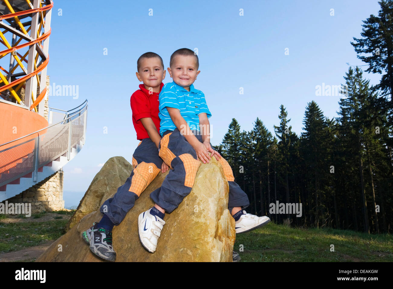 Boys, 6 and 4 years, sitting on a rock Stock Photo