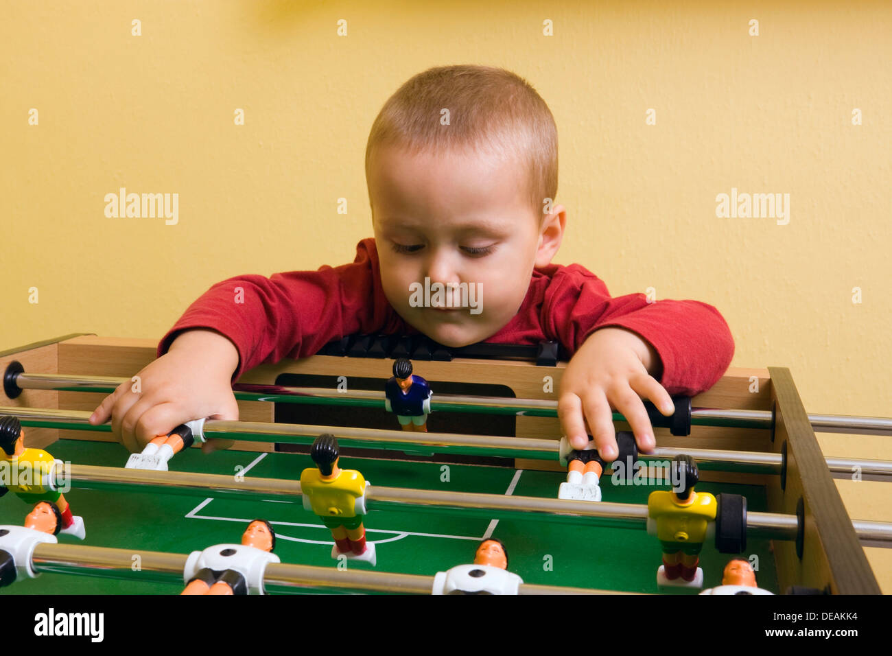 Boy, 2 years, playing with tabletop soccer Stock Photo