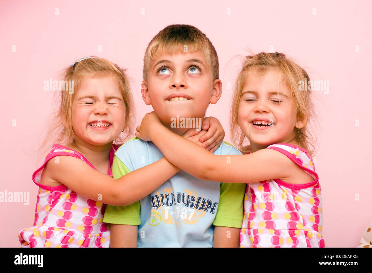 Twin girls, 3 years, and their brother, 7 years Stock Photo