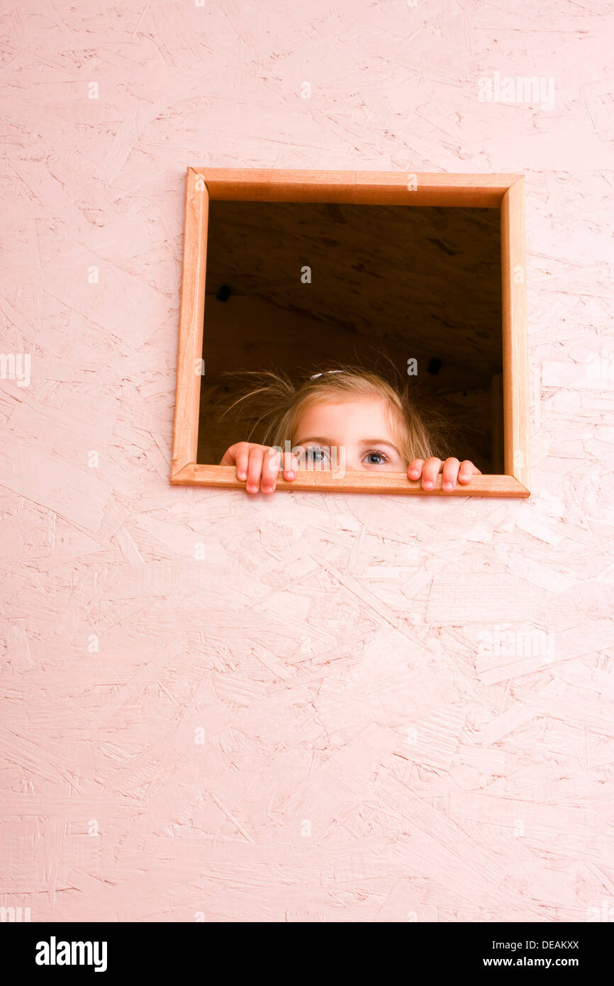 Girl, 3 years, looking through window Stock Photo