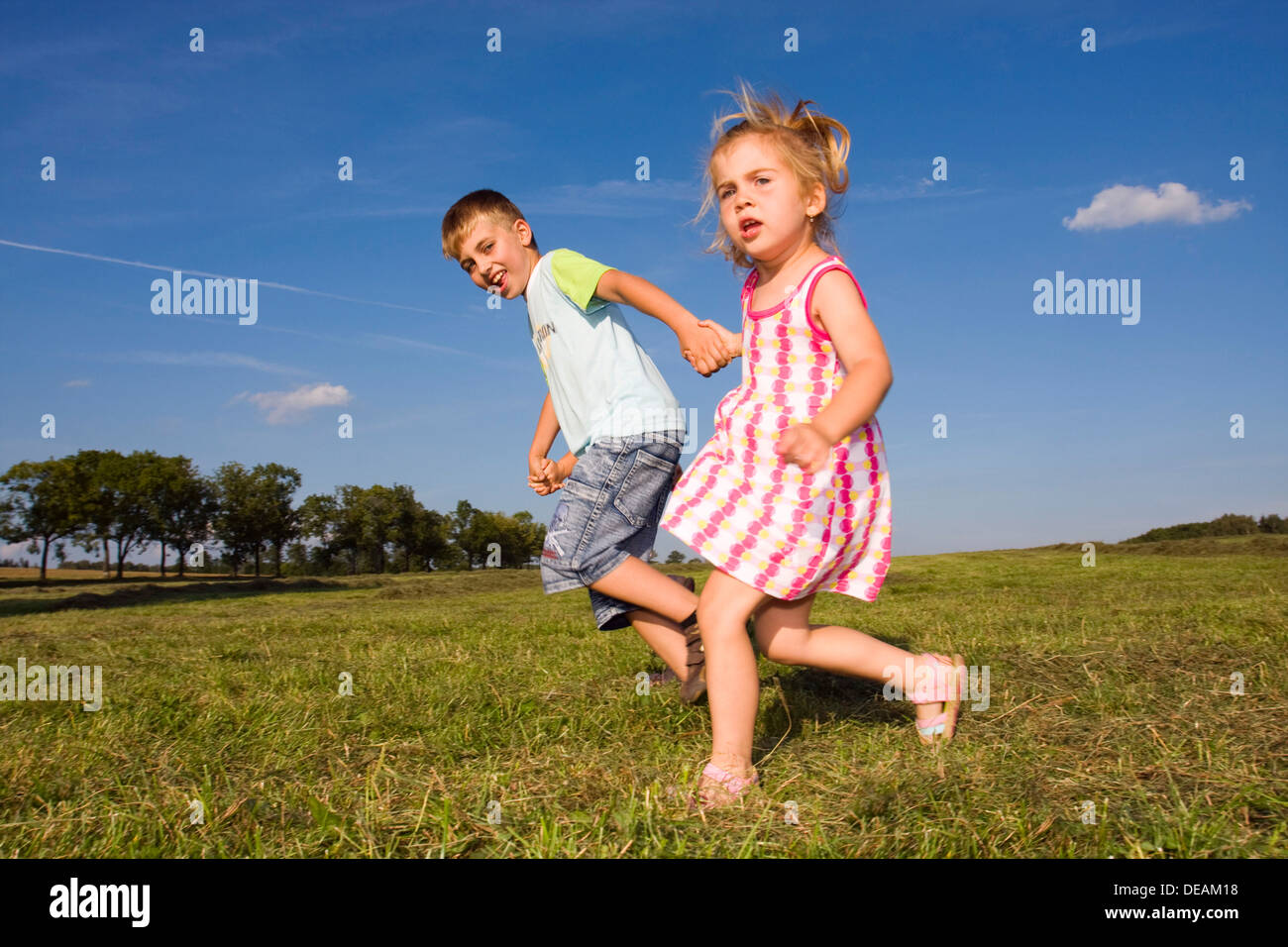 Little girl, 3 years, and her brother, 7 years, outdoors Stock Photo