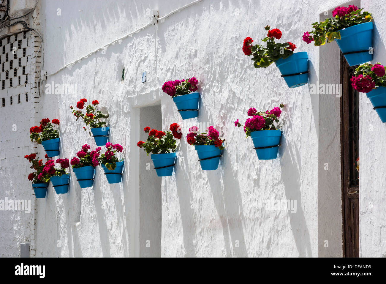 Street of Mijas in Spain with typical geraniums in blue pots Stock Photo