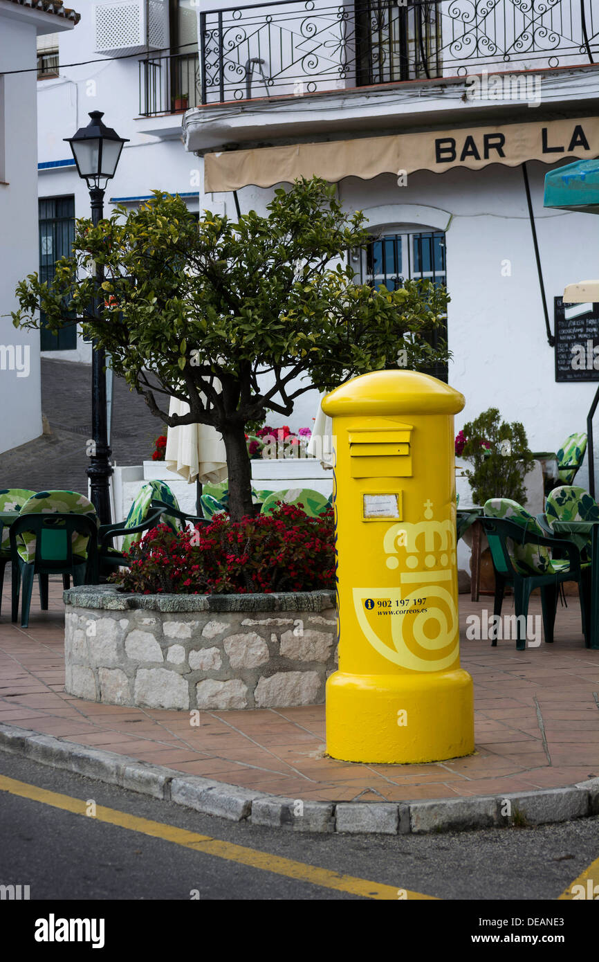 A  yellow Spanish post box positioned on a village street corner Stock Photo
