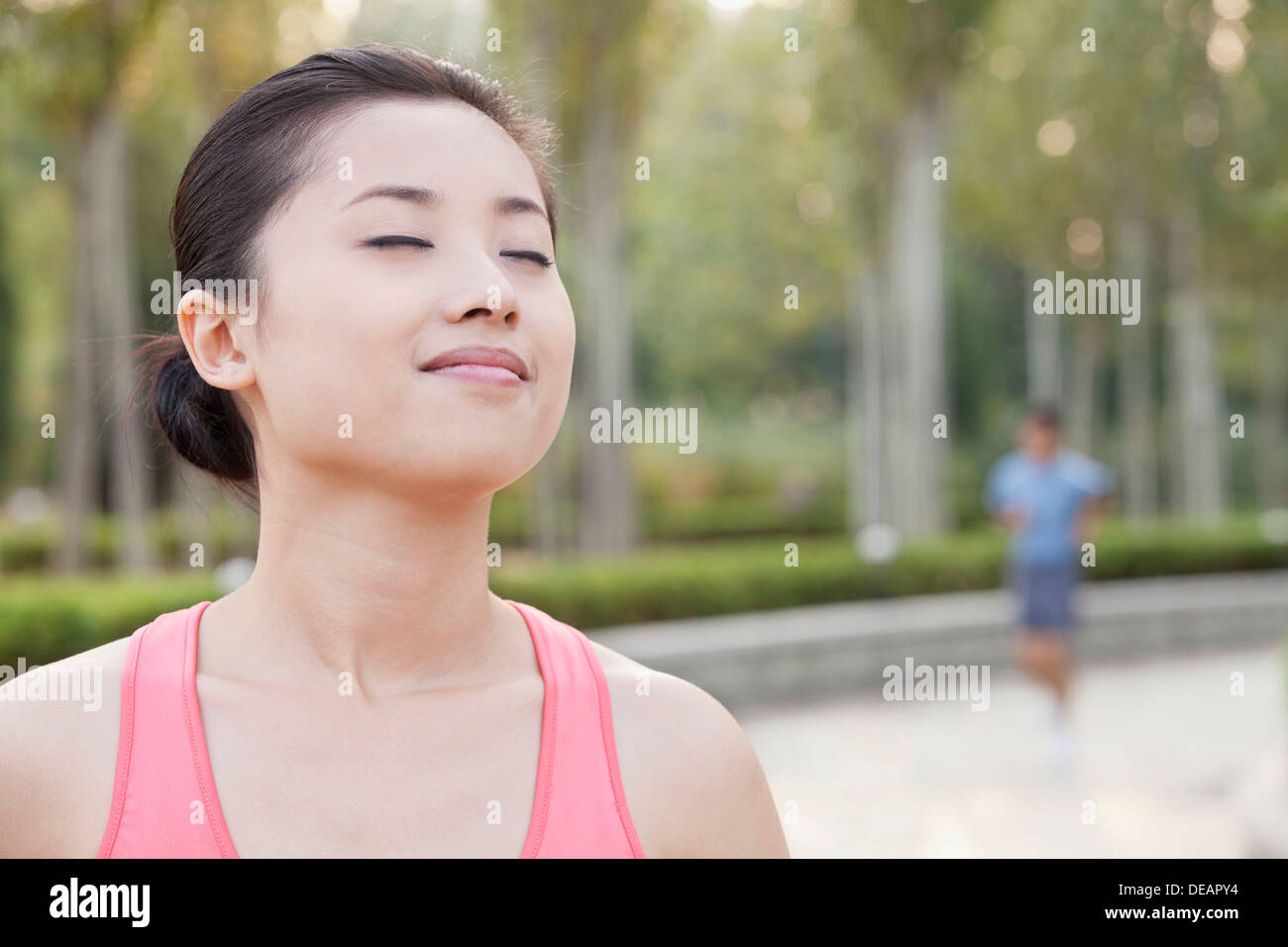Young Woman With Eyes Closed in Park in Beijing Stock Photo - Alamy