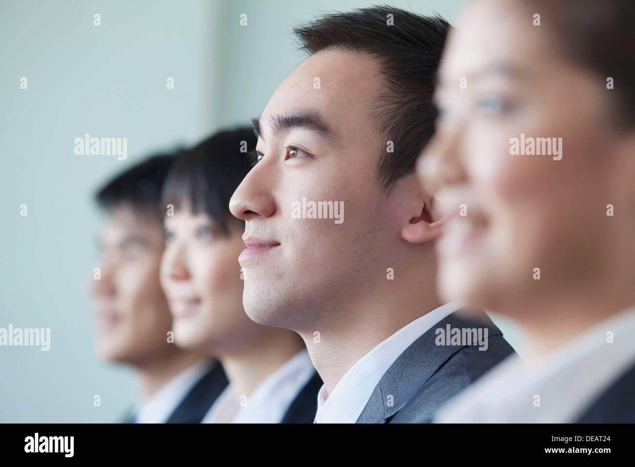 Four Business people sitting in a row, portrait Stock Photo - Alamy