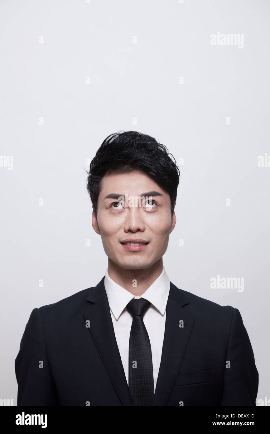 Businessman smiling and looking up, studio shot Stock Photo