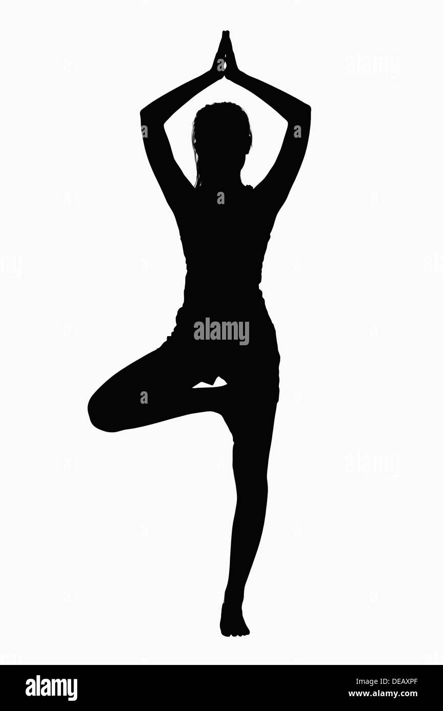 Silhouette of woman doing yoga pose. Stock Photo