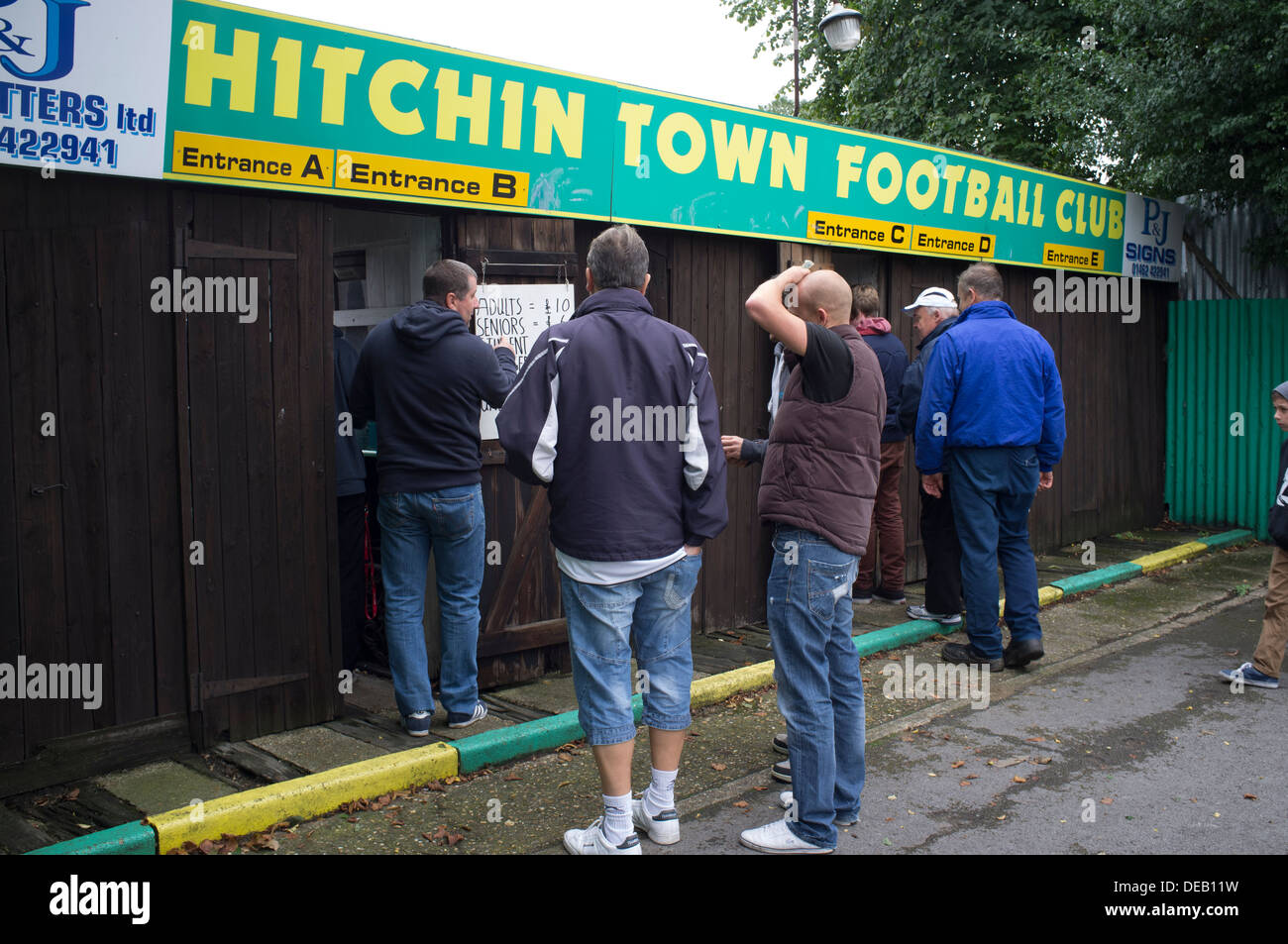 General view of spectators entering Hitchin Town FC on match day through old fashioned turnstiles. Stock Photo