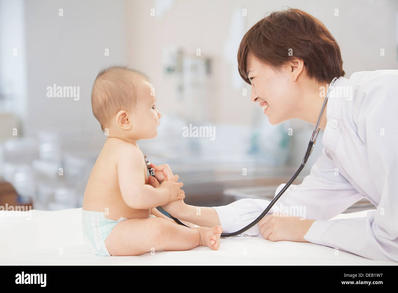Doctor checking baby's heart beat with a stethoscope in the doctors