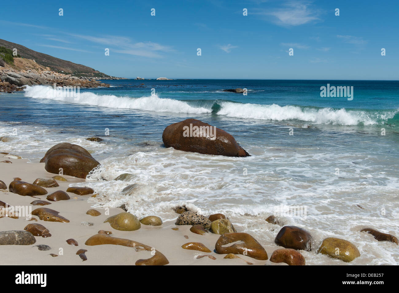 Beach with rocks polished smooth by the sea ocean in the background, Victoria Road south of Cape Town, South Africa Stock Photo