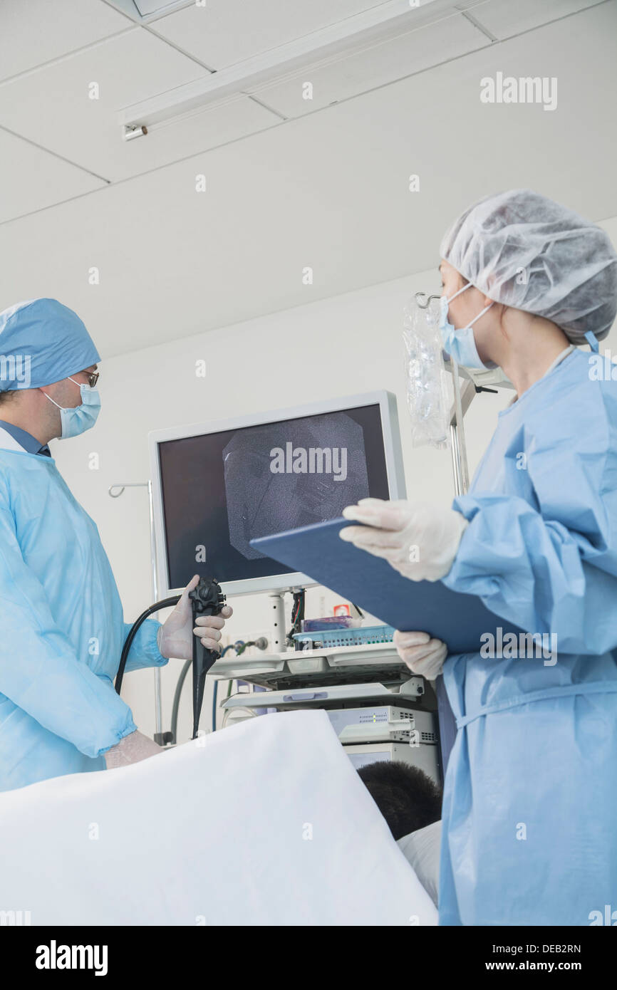 Two surgeons preparing for surgery, patient lying down Stock Photo - Alamy