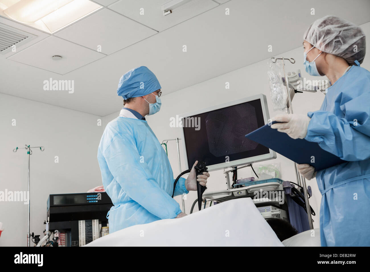 Two surgeons preparing for surgery, patient lying down Stock Photo - Alamy