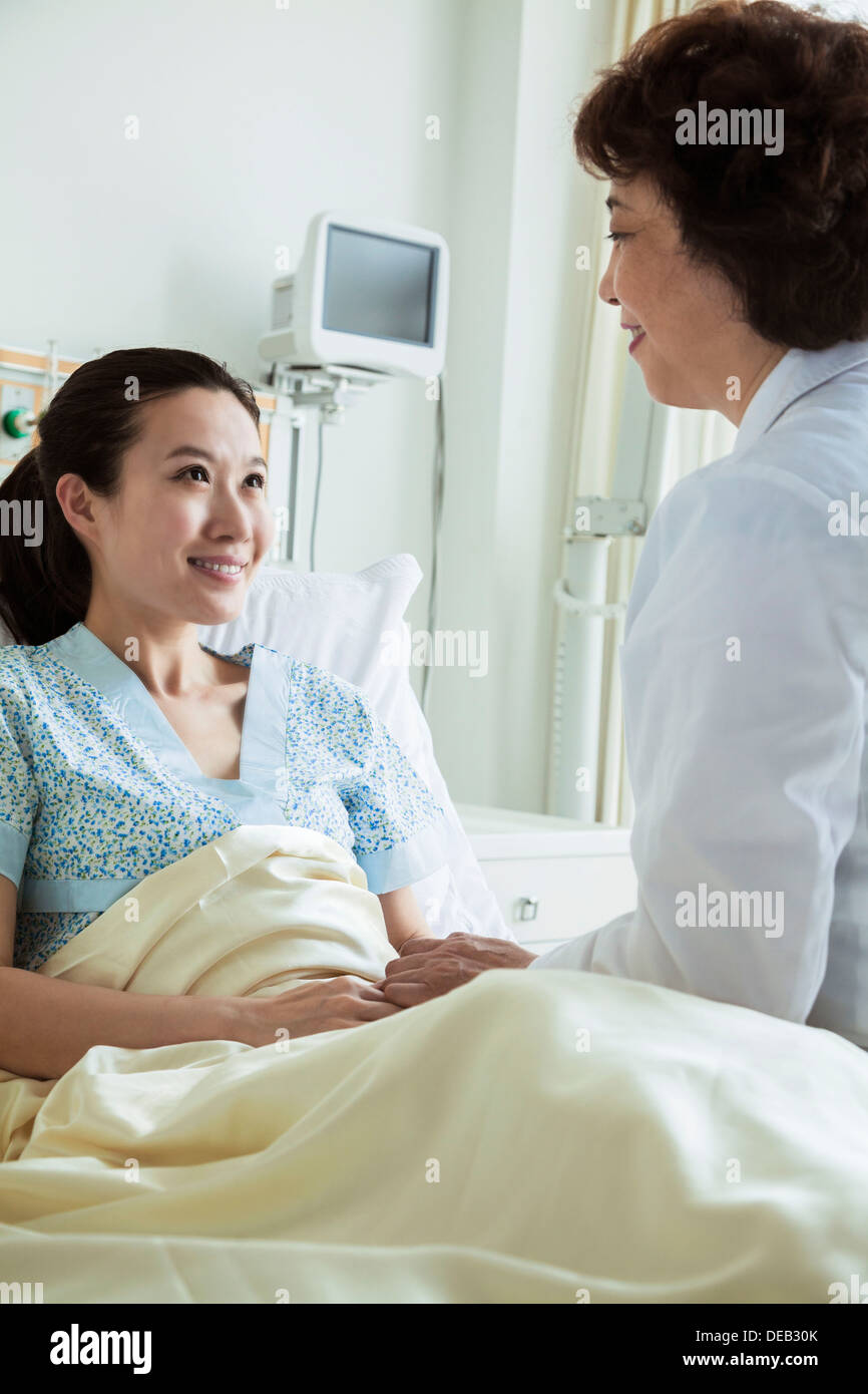 Female doctor sitting on bed hi-res stock photography and images - Alamy