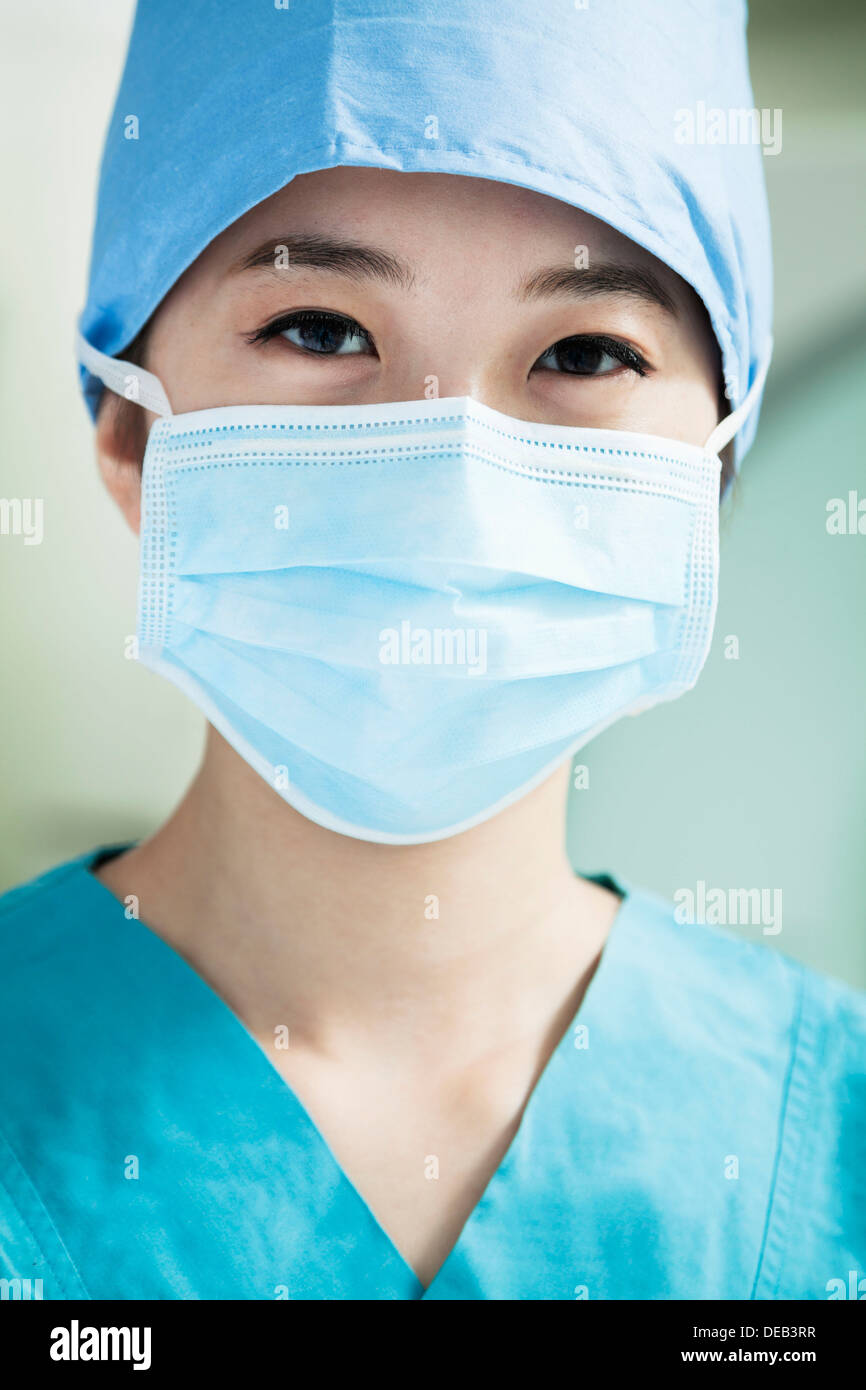 Portrait of young female surgeon wearing surgical mask in the operating ...