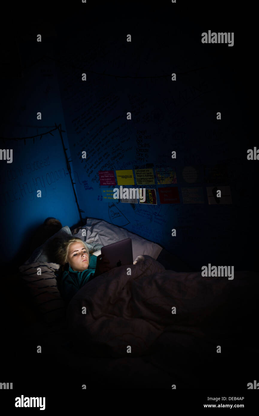 A fourteen year old teenage girl reading her Facebook on her iPad