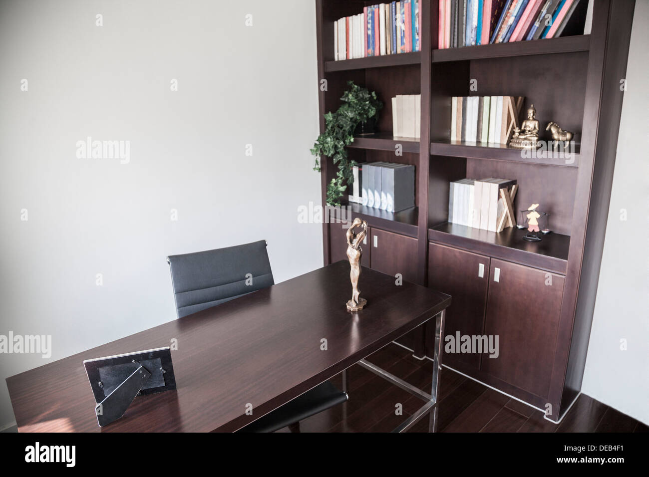 Modern home office with bookshelves and sculptures Stock Photo Alamy