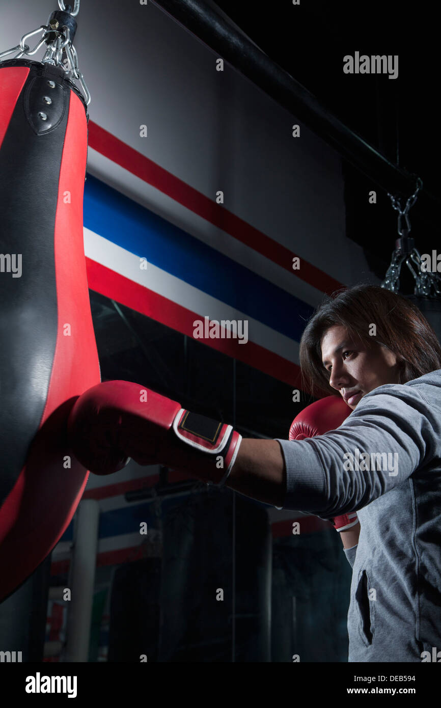 Determined boxer training at the gym on the punch bag Stock Photo - Alamy