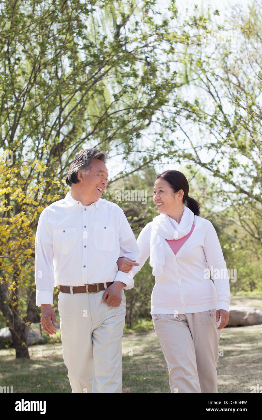 Happy senior couple holding hands and going for a walk in the park in ...