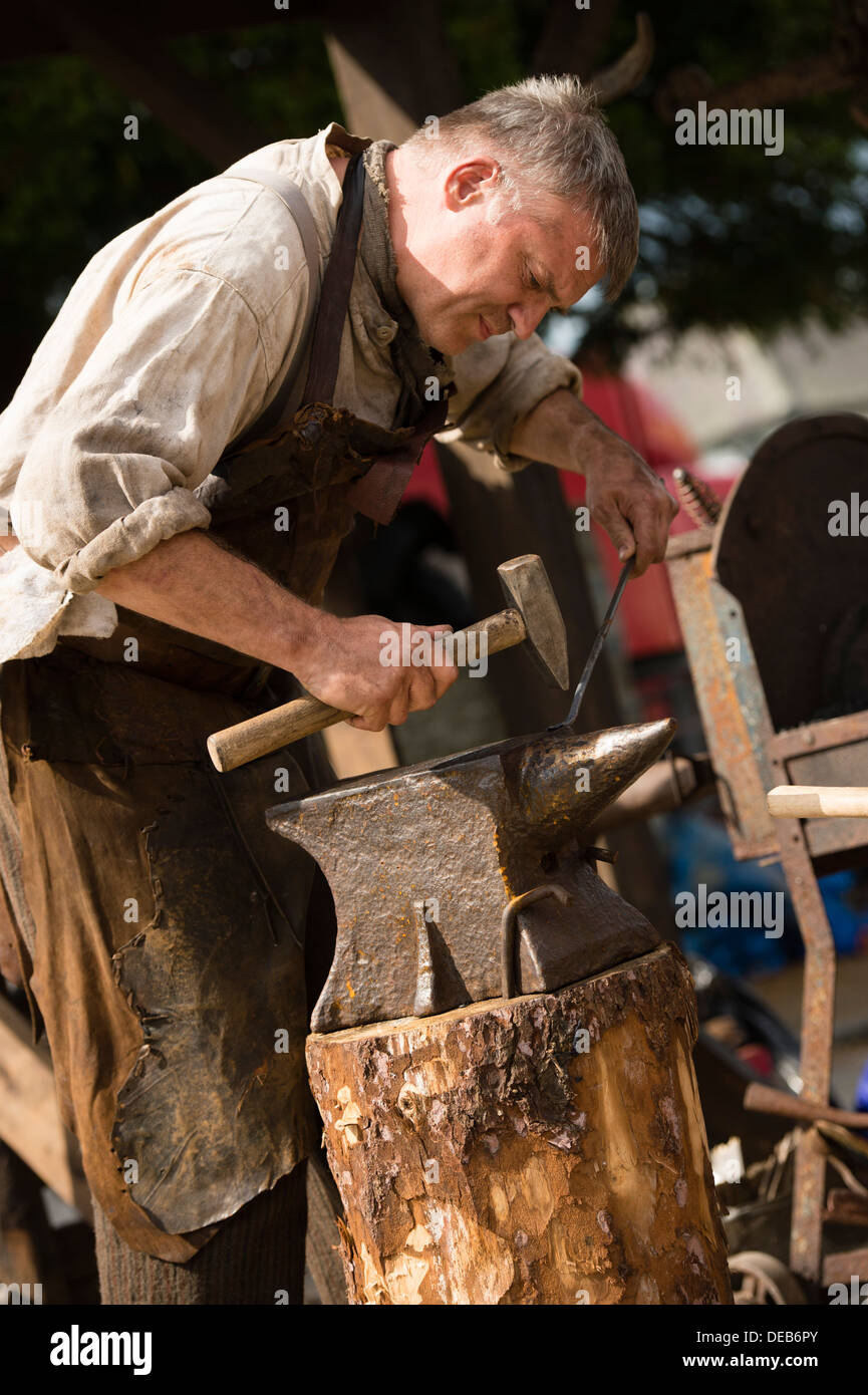 A traditional blacksmith hammering a glowing piece of metal on an anvil