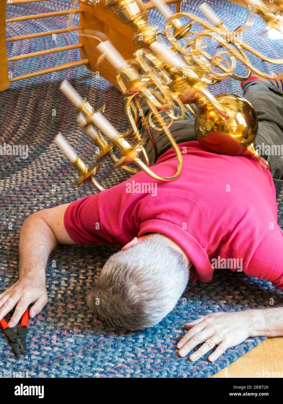 Senior Man Has Home Improvement Failure with Chandelier Stock Photo