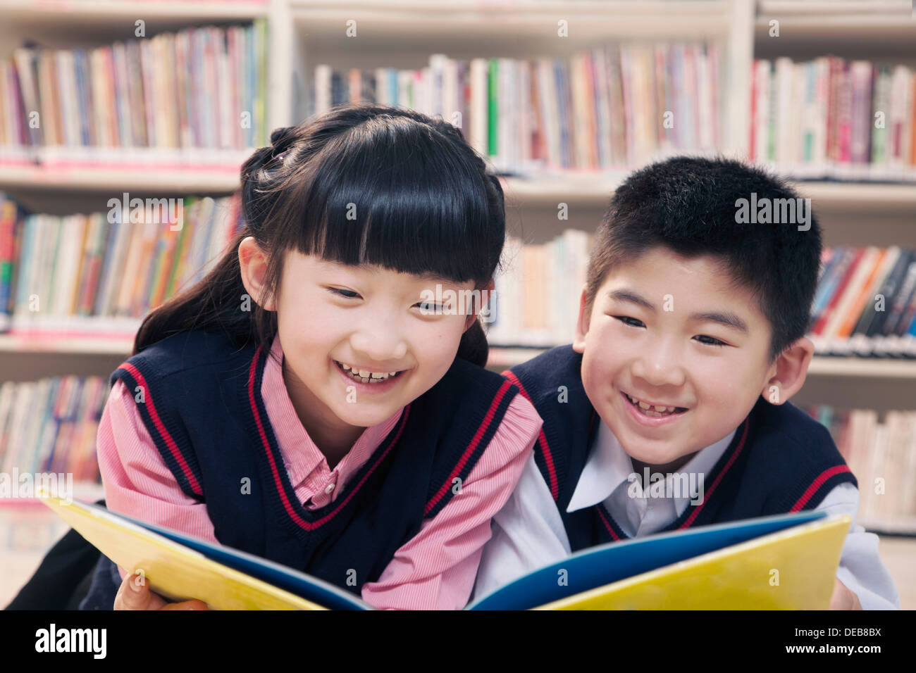 School children reading book a in the library Stock Photo