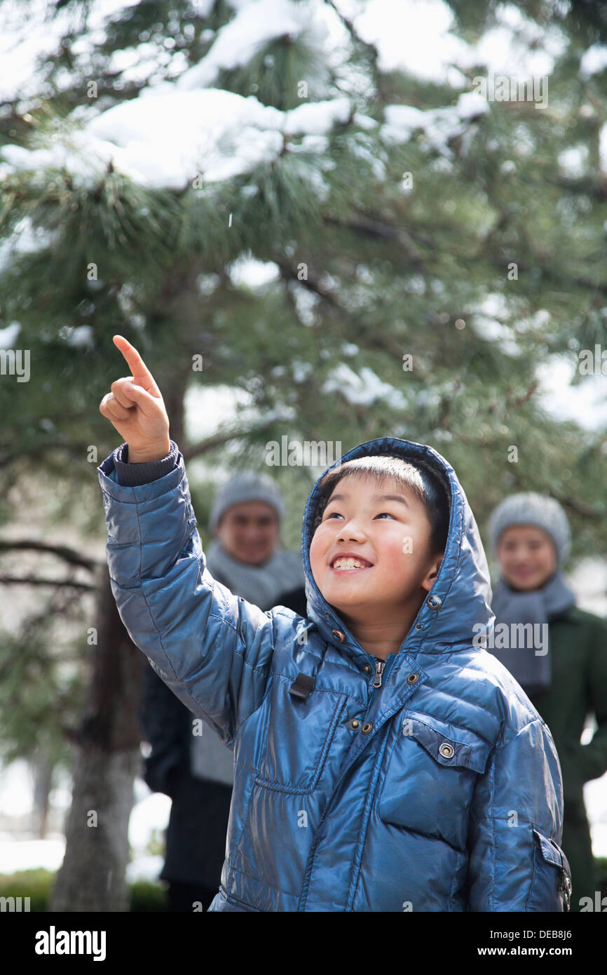 Boy pointing up with parents on the background Stock Photo - Alamy