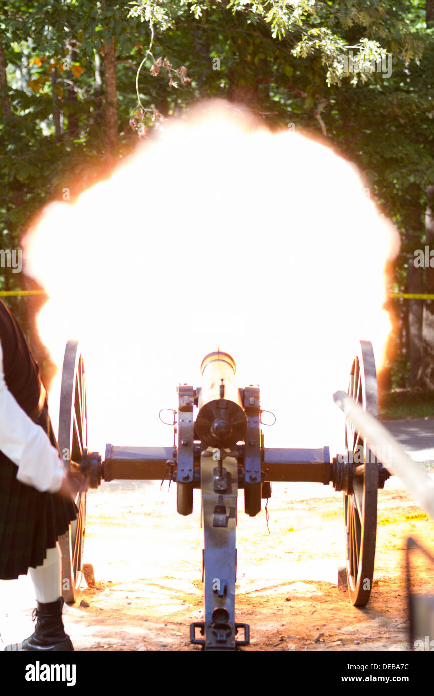 Fire and smoke as a Civil War reenactor fires a functional, 19th century mountain howitzer (cannon) at a folk festival Stock Photo