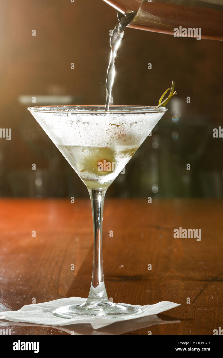dirty vodka martini splashing into a cocktail glass with green olives Stock Photo Alamy