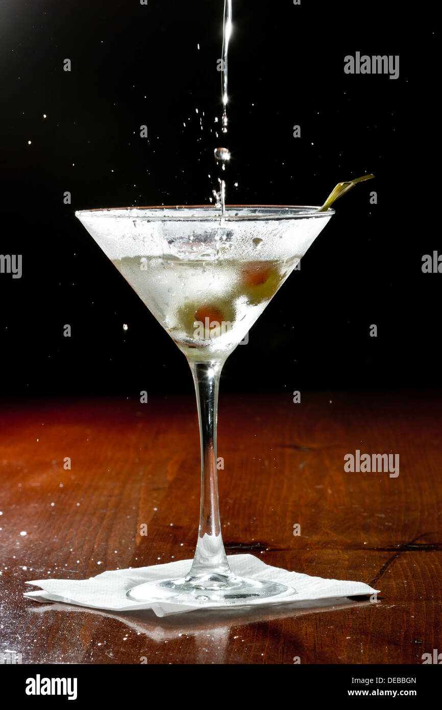 dirty vodka martini splashing into a cocktail glass with green olives Stock Photo Alamy