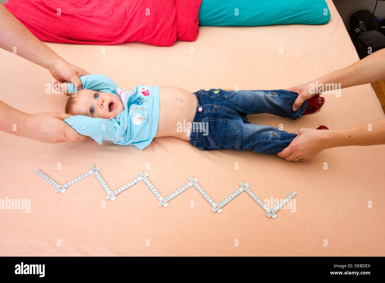 Parents measuring a baby, 1 year Stock Photo Alamy
