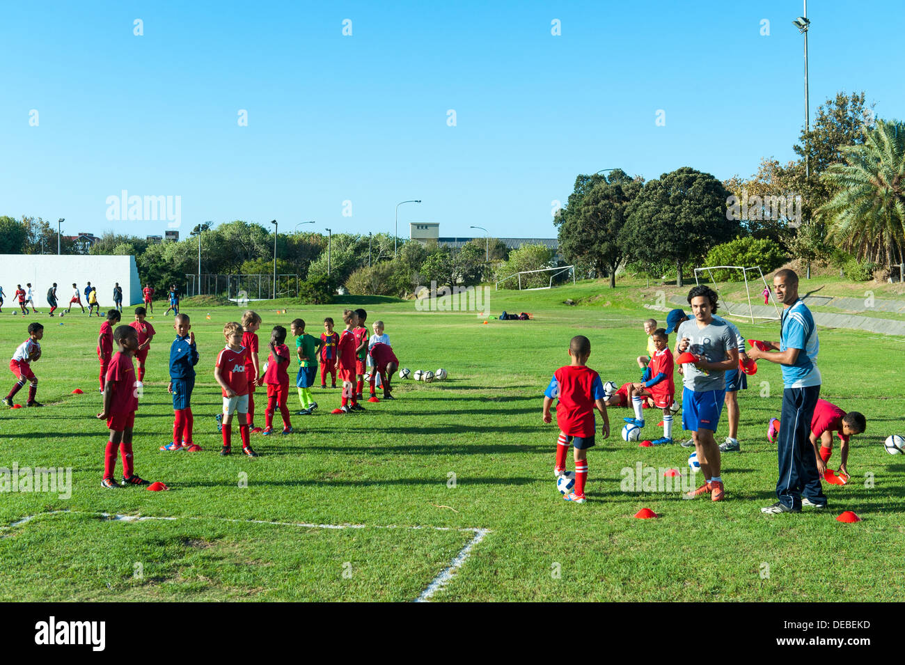 Junior football players with coaches at practice, Cape Town, South Africa Stock Photo