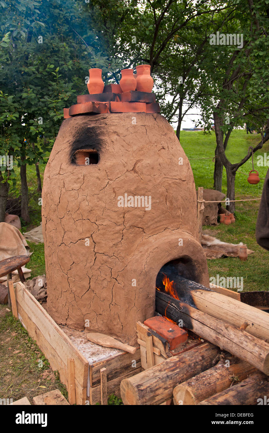 clay stove with long whole fire woods burning on it Stock Photo