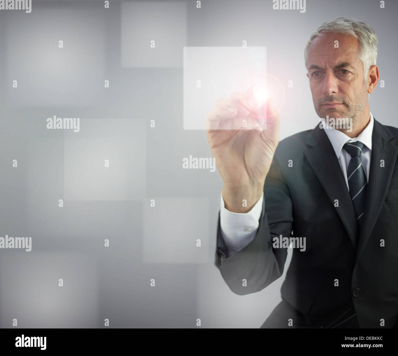 Serious businessman touching empty pane on digital screen Stock Photo