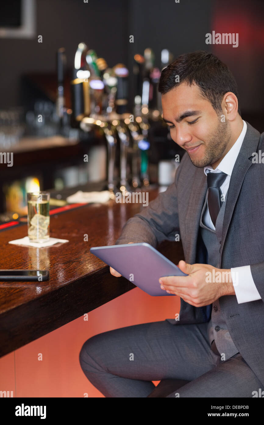 Smiling businessman working on his tablet computer Stock Photo