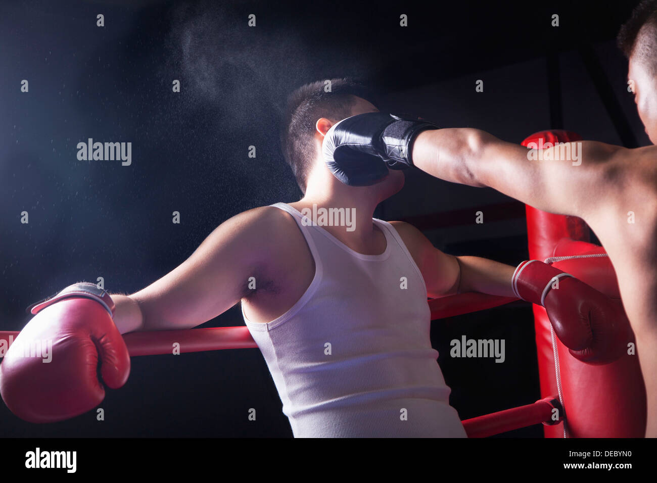 Over the shoulder view of male boxer throwing a knockout punch in the