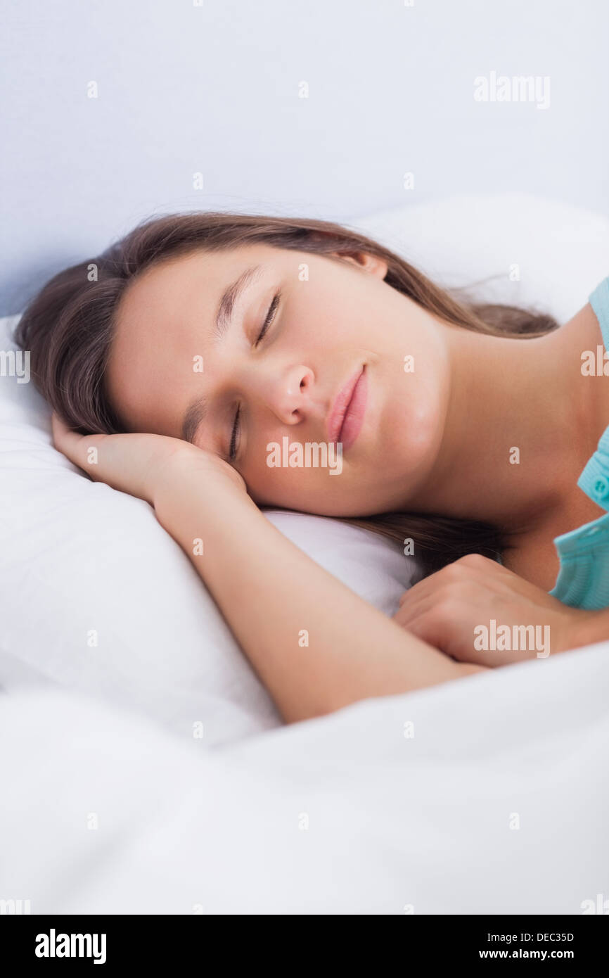 Brunette woman asleep in bed Stock Photo