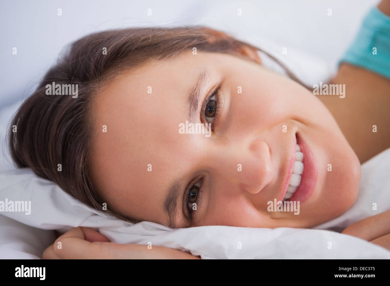 Pretty woman lying in bed looking into the camera Stock Photo