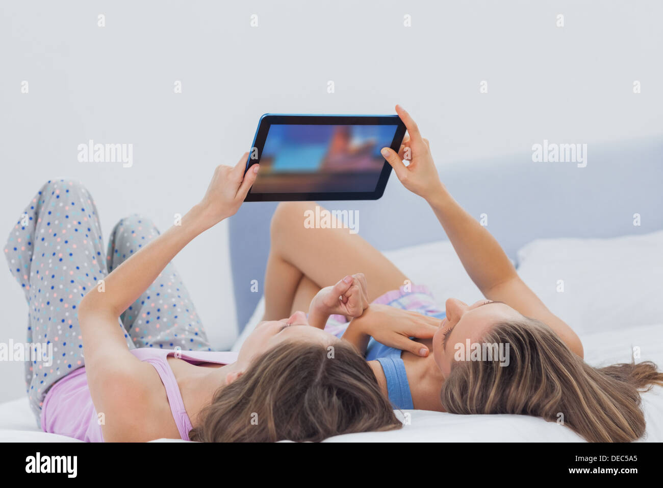 Friends wearing pajamas holding tablet Stock Photo