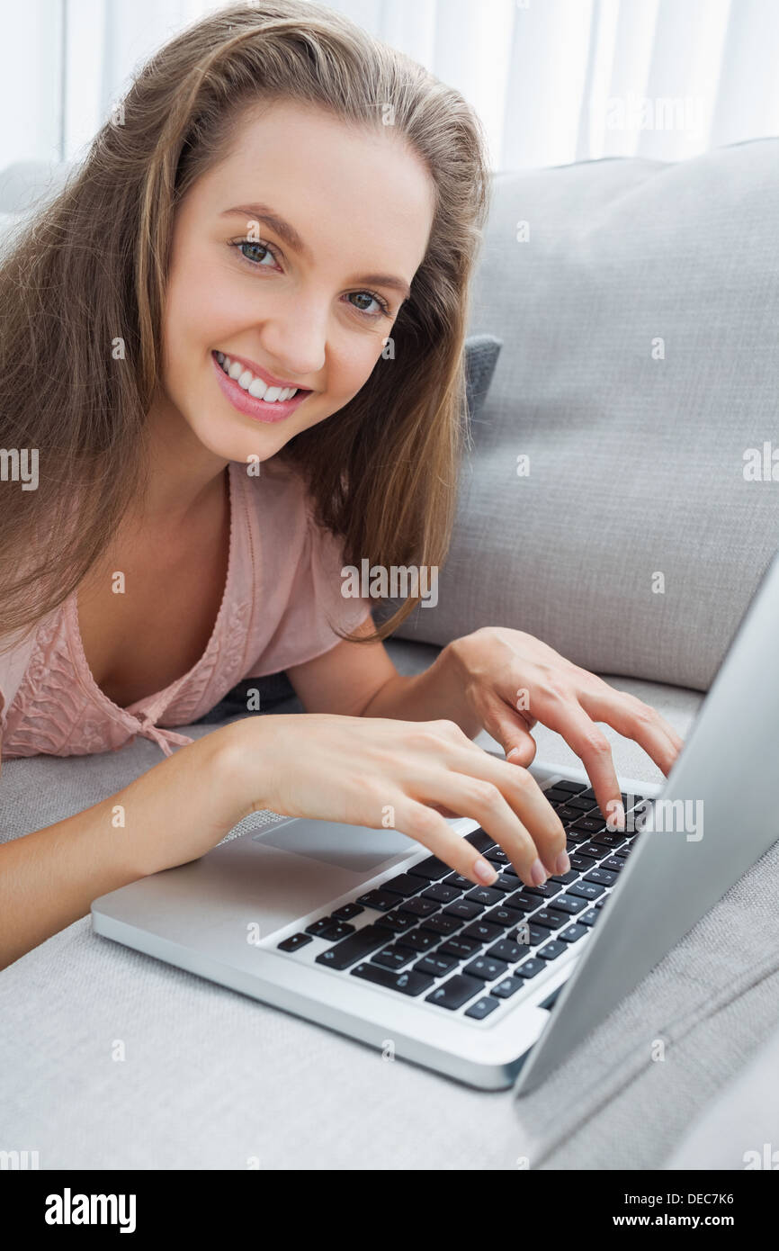 Woman using laptop on sofa Stock Photo