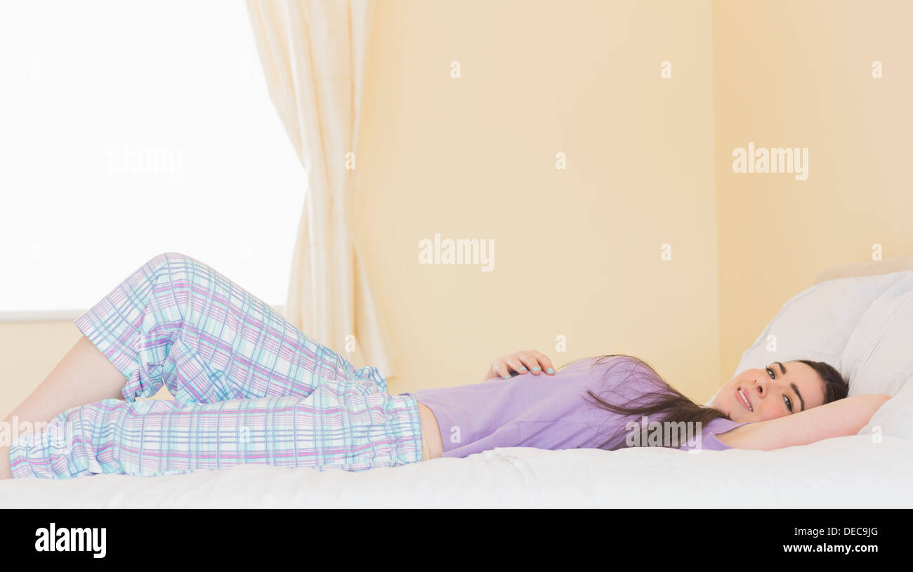 Cheerful girl lying on bed and looking Stock Photo - Alamy