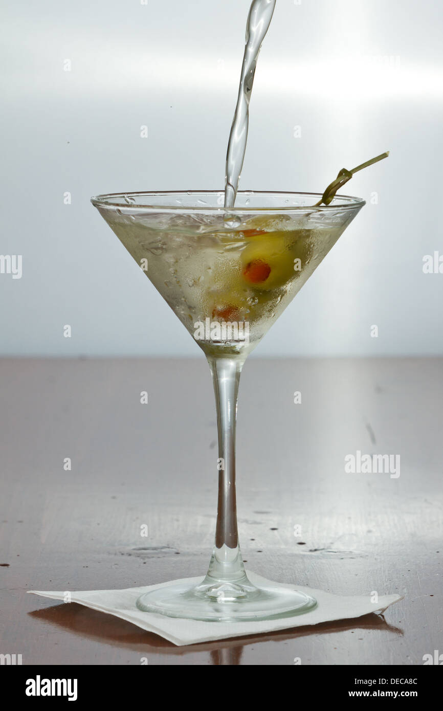 dirty vodka martini splashing into a cocktail glass with green olives Stock Photo Alamy