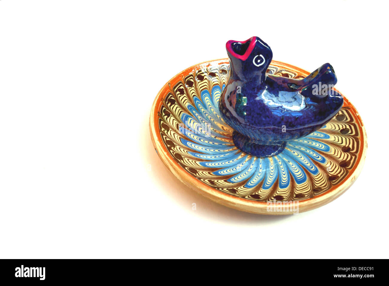 Isolated Blue Chicken Whistle on a Cobalt Ceramic Plate. Stock Photo