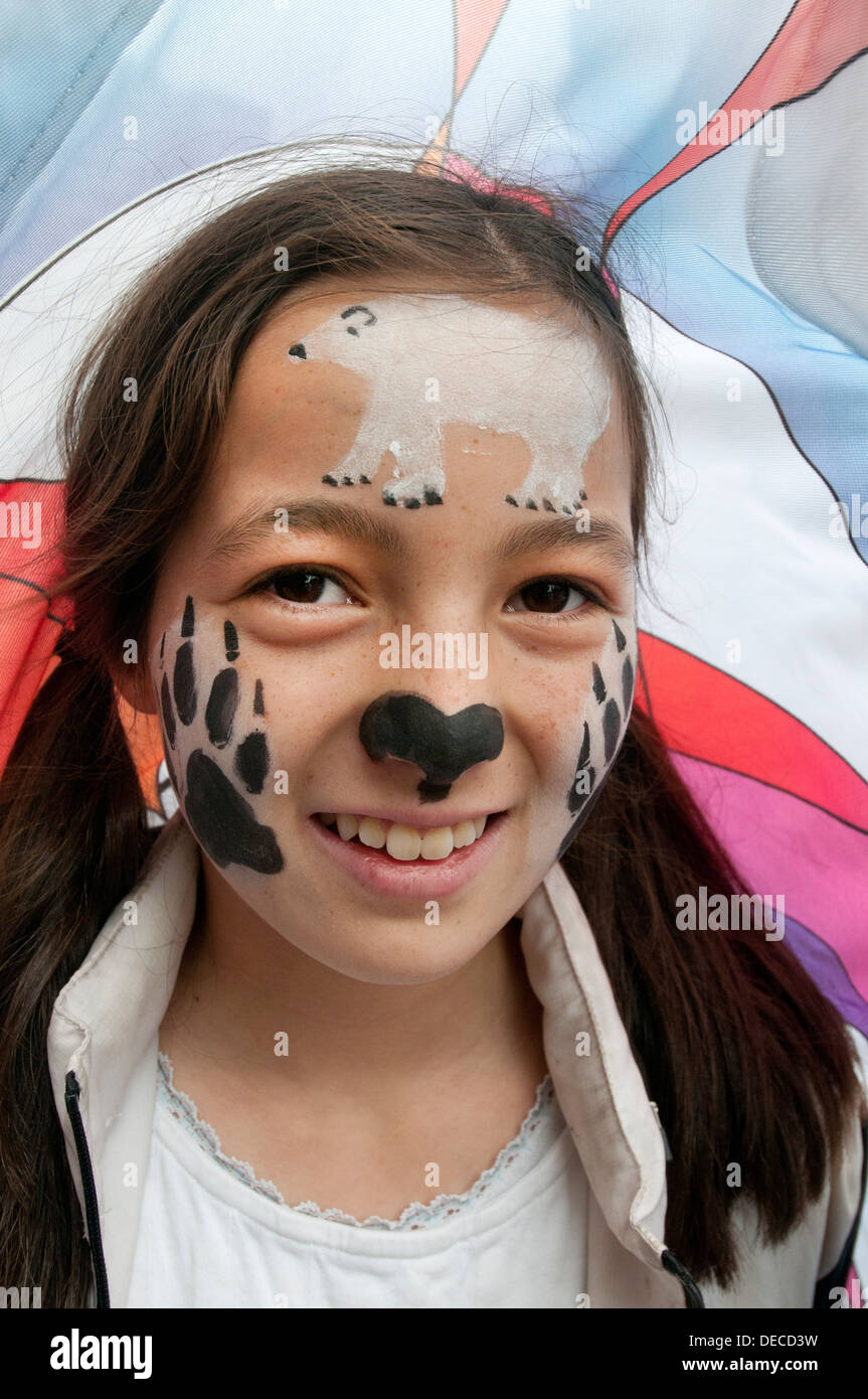 A young protester wears polar bear face paint in front of Aurora, the double-decker-bus-size polar bear puppet Stock Photo