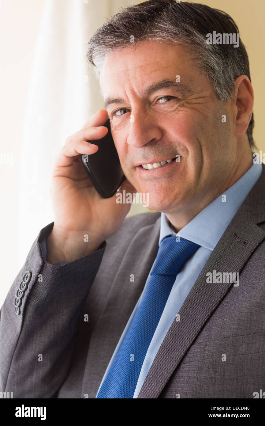 Smiling man calling someone with his mobile phone Stock Photo