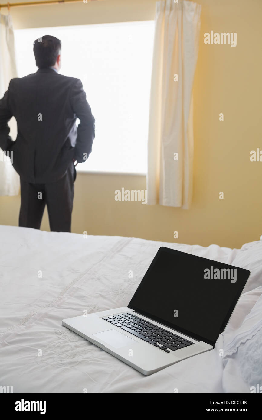 Man standing by the window looking out Stock Photo