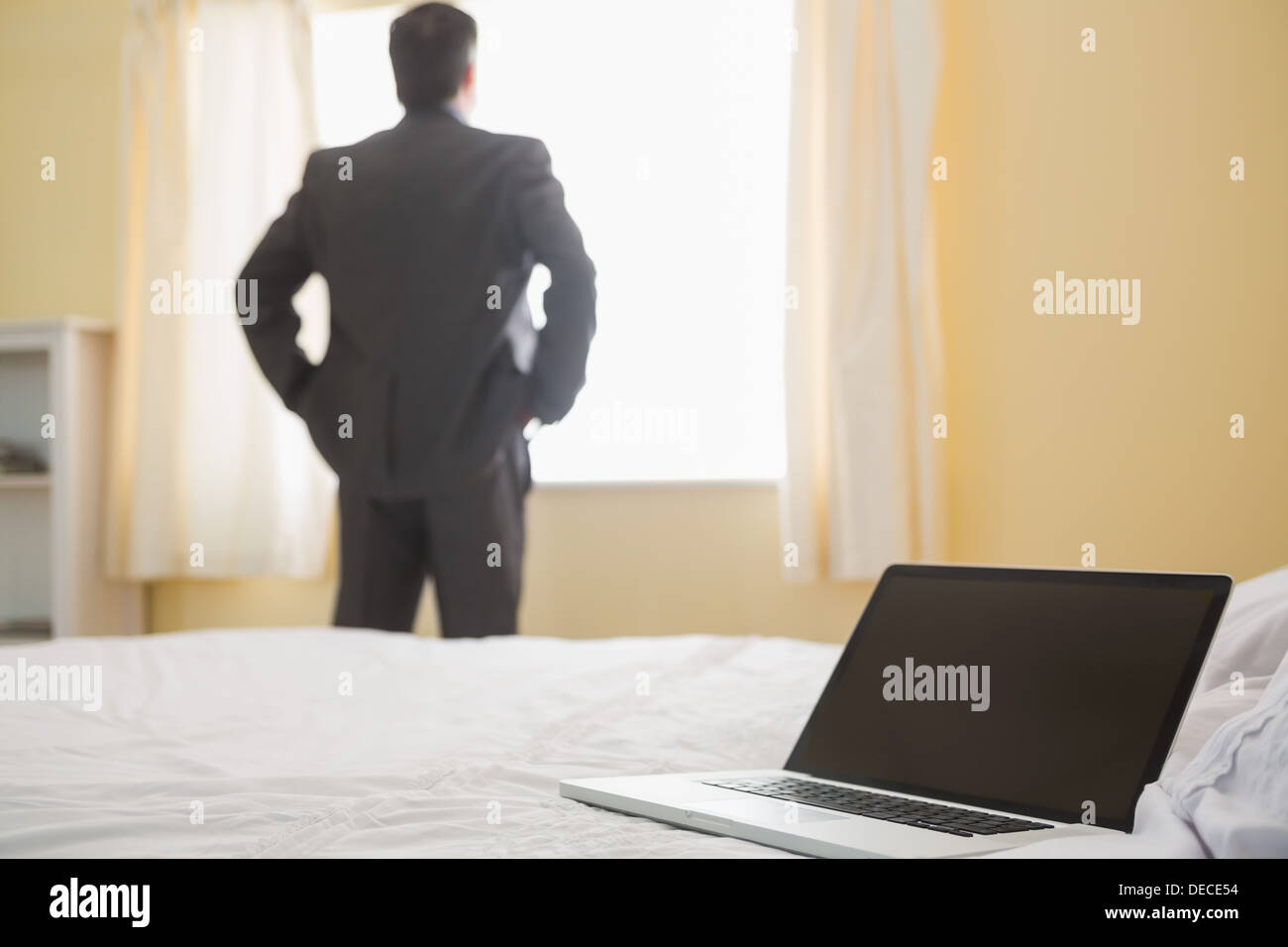 Man standing back in front of the window hands in the pockets Stock Photo
