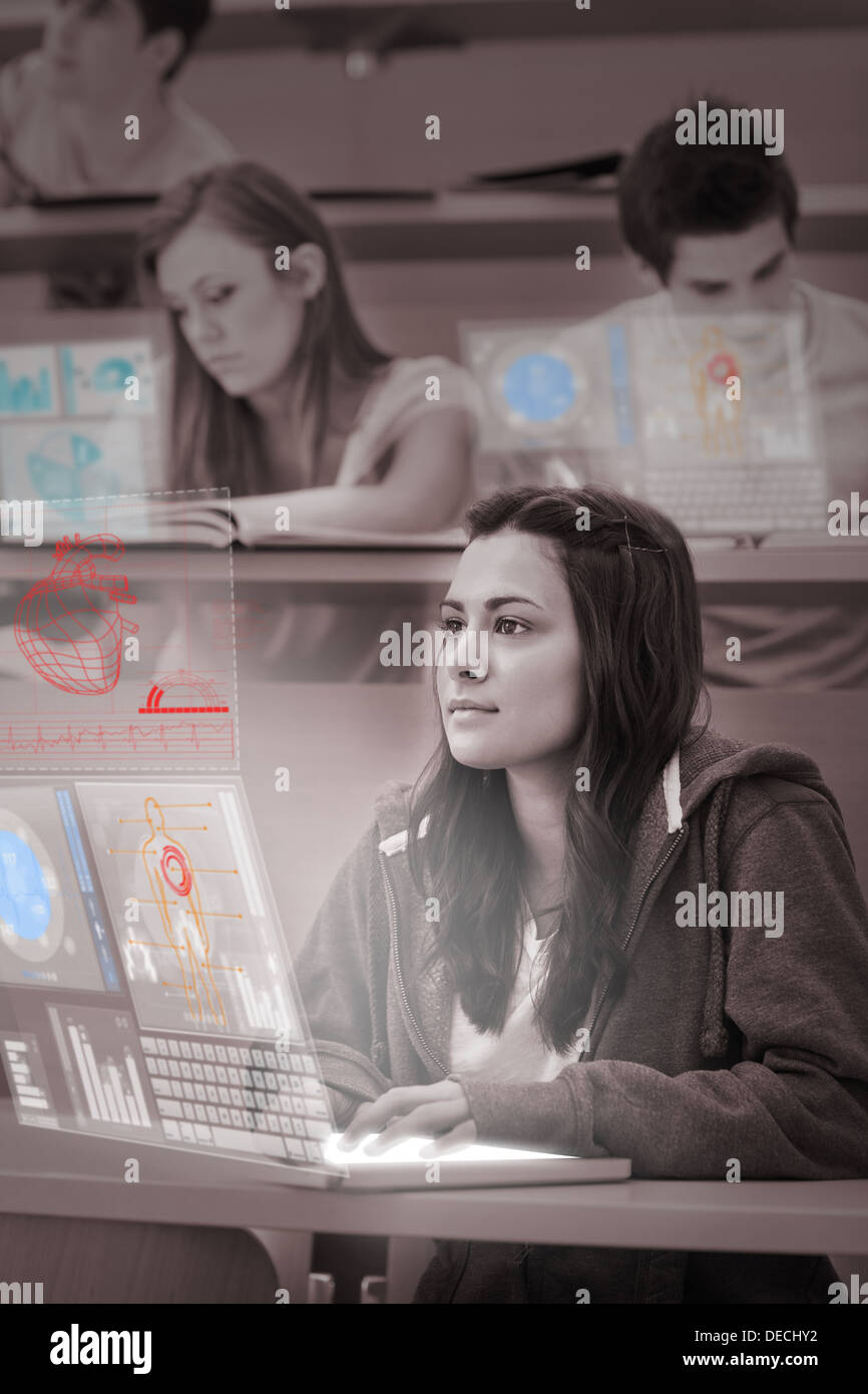 Focused pretty student working on her futuristic laptop Stock Photo